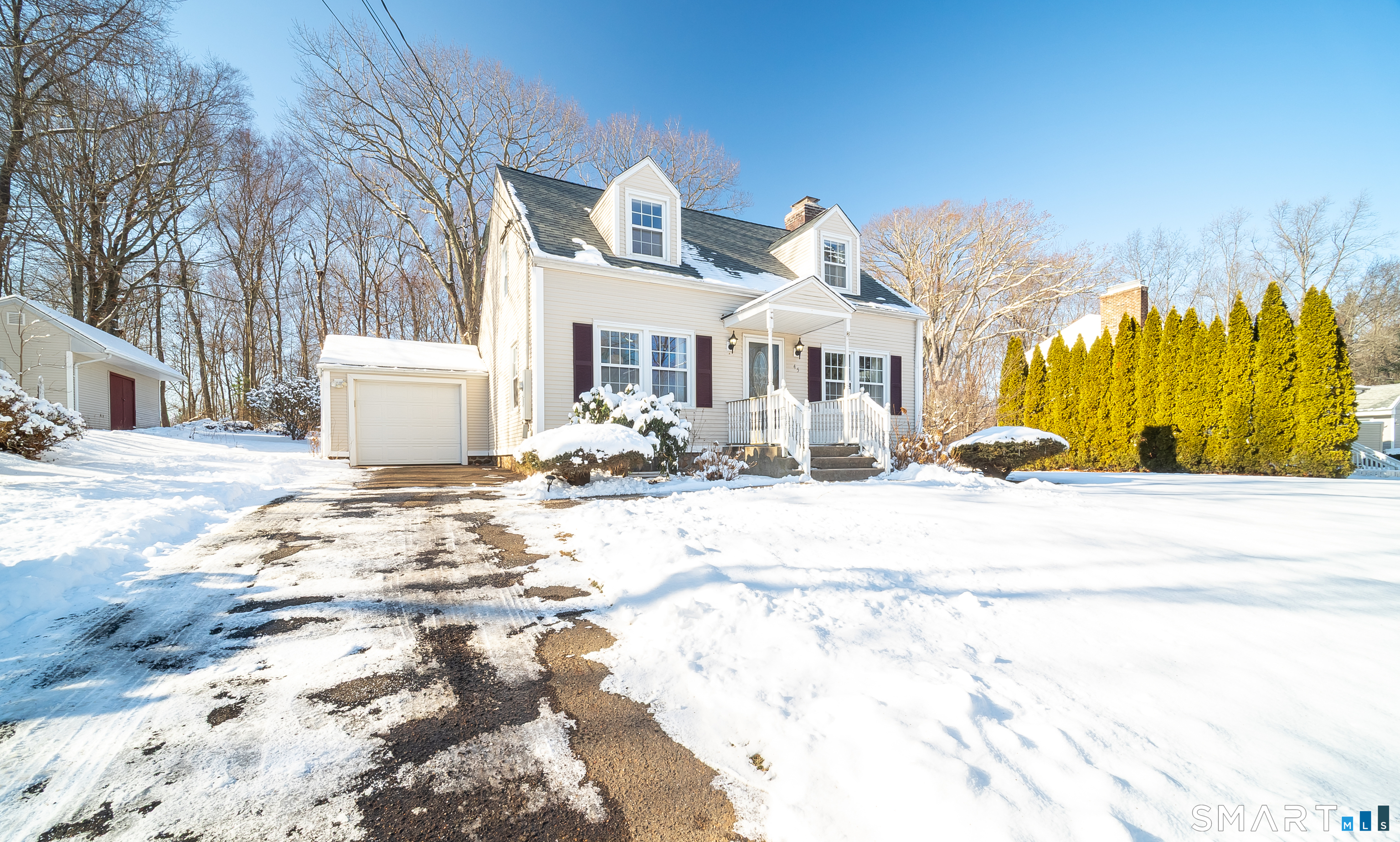 a view of a white house with a snow on the road
