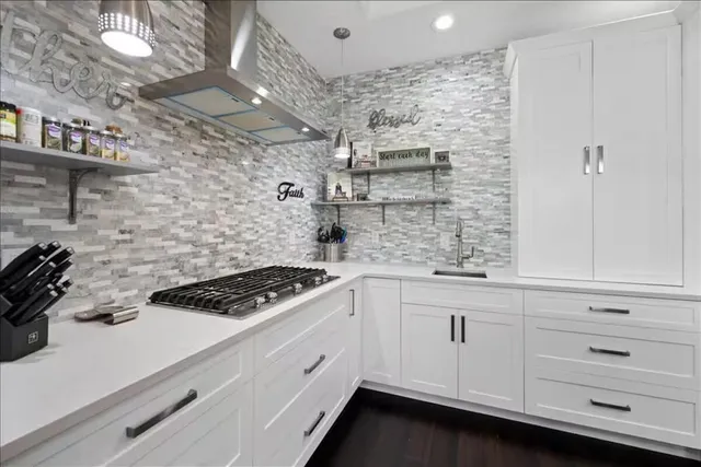 a kitchen with white cabinets and appliances