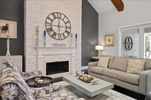 a living room with furniture a fireplace and wall paintings