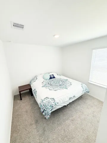 a bed sitting in a bedroom next to a window