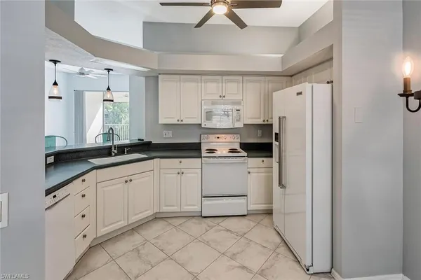 a kitchen with granite countertop cabinets and white appliances