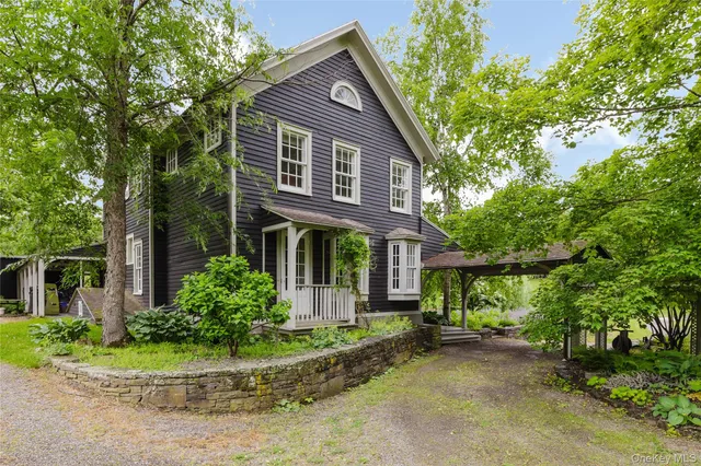 a front view of a house with a yard and potted plants