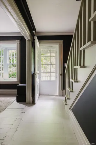 a view of an empty room with wooden floor and stairs