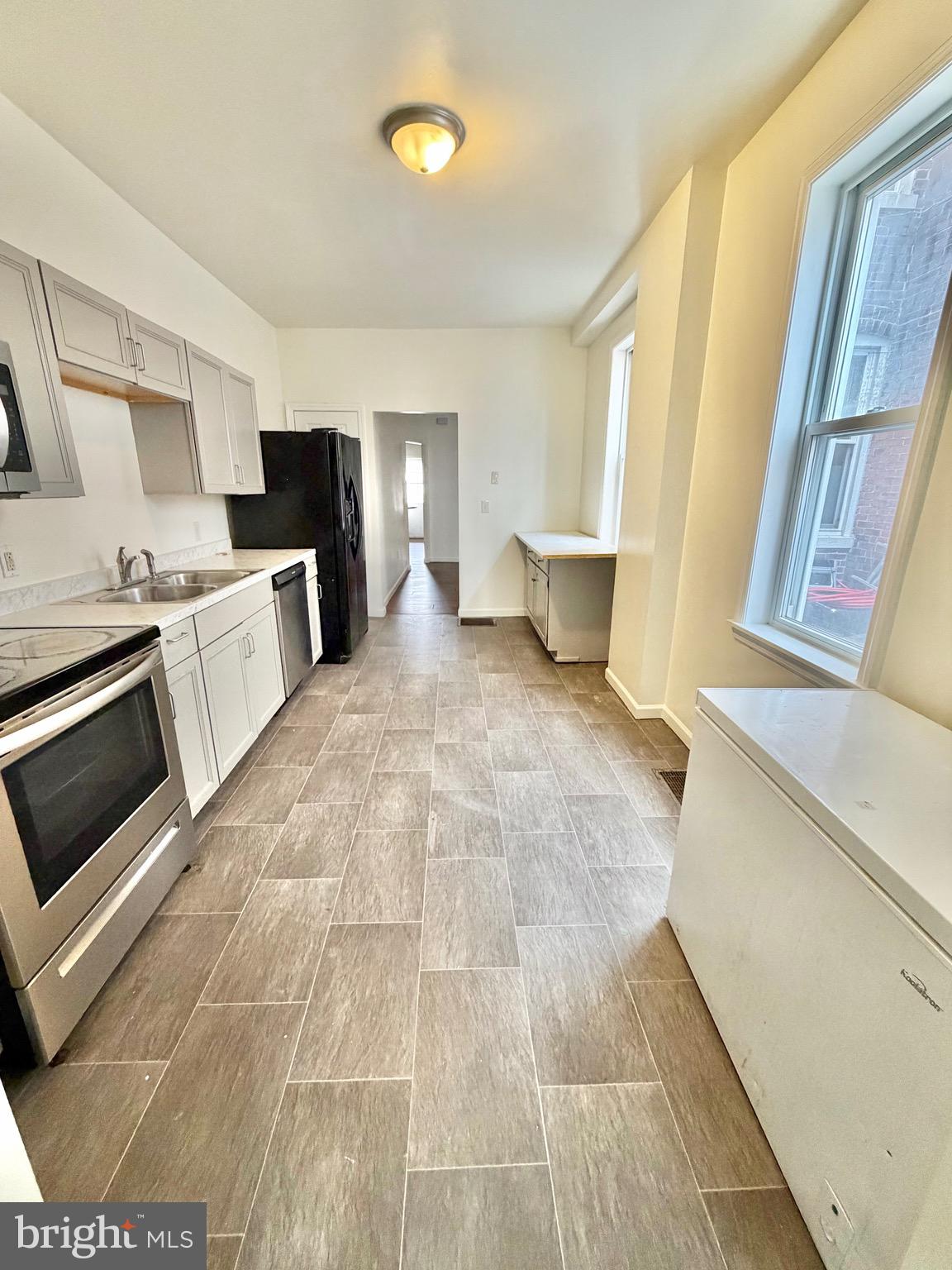 1211 West Poplar Street York, PA 17404 - Photo 12 of 38 a large white kitchen with cabinets and a stove