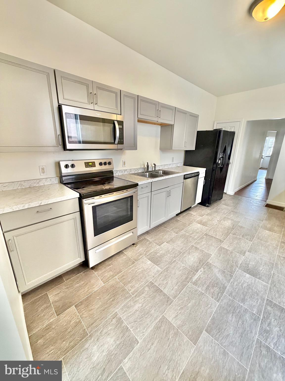 1211 West Poplar Street York, PA 17404 - Photo 13 of 38 a kitchen with stainless steel appliances a stove a microwave and a sink