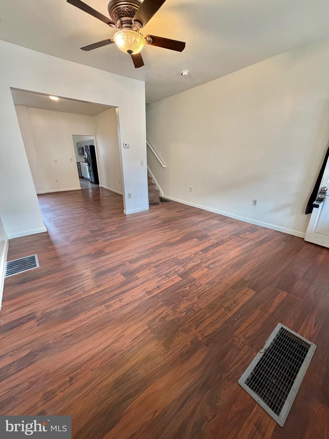 1211 West Poplar Street York, PA 17404 - Photo 4 of 38 an empty room with wooden floor a ceiling fan and windows