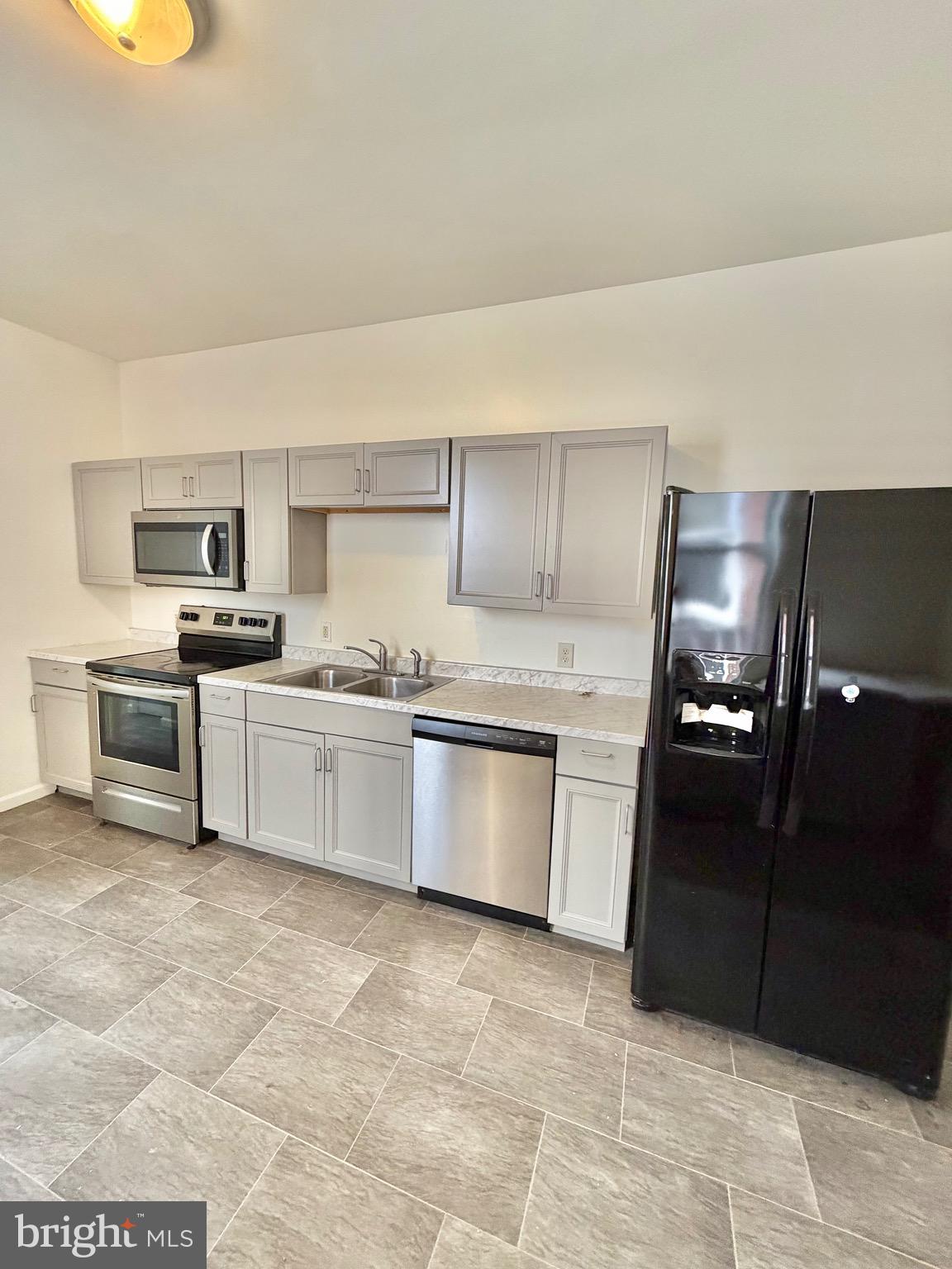 1211 West Poplar Street York, PA 17404 - Photo 7 of 38 a kitchen with granite countertop a refrigerator sink and cabinets