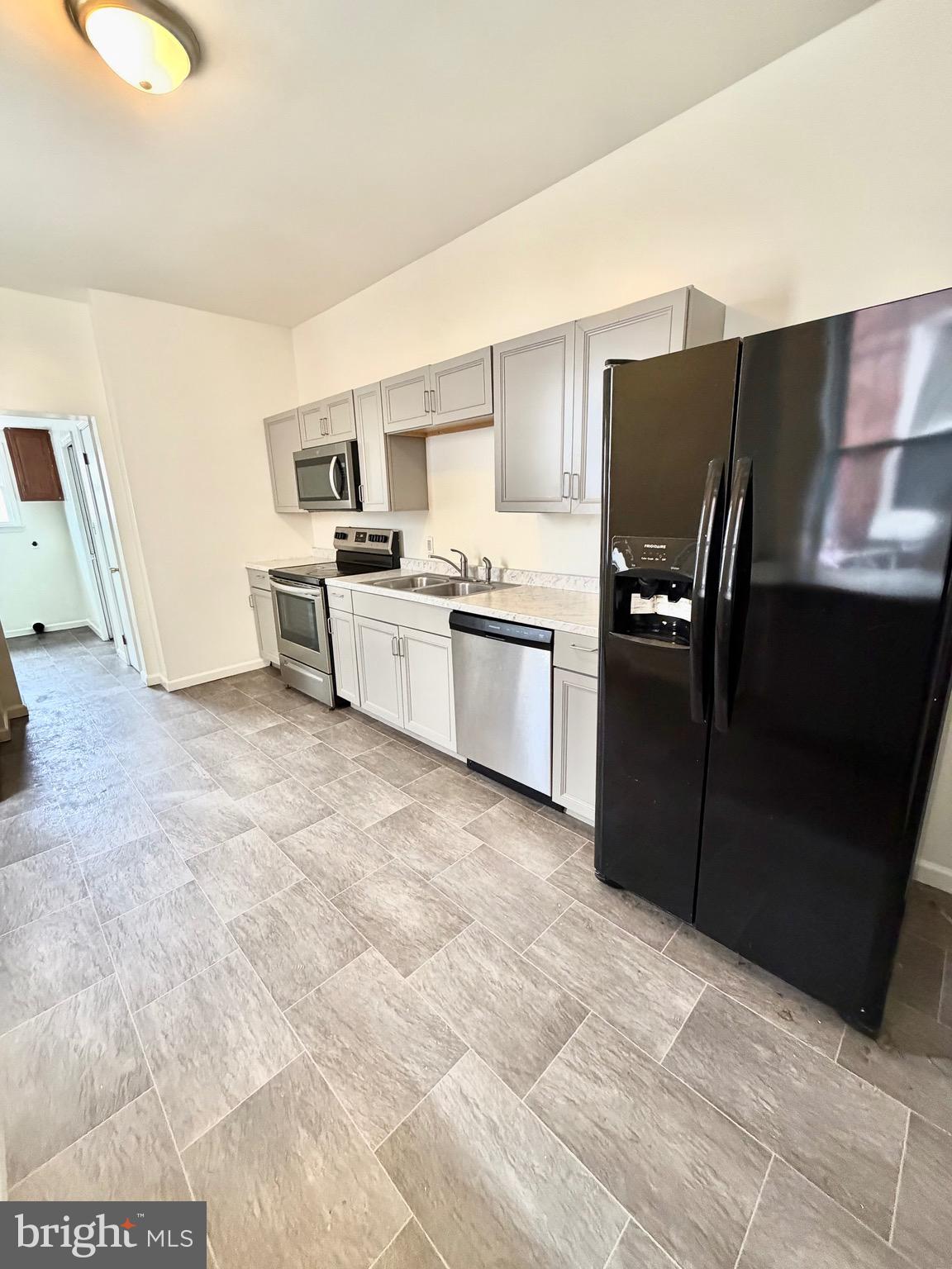1211 West Poplar Street York, PA 17404 - Photo 8 of 38 a kitchen with granite countertop a refrigerator and a stove top oven