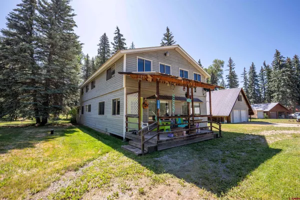 a view of a house with a yard patio and fire pit