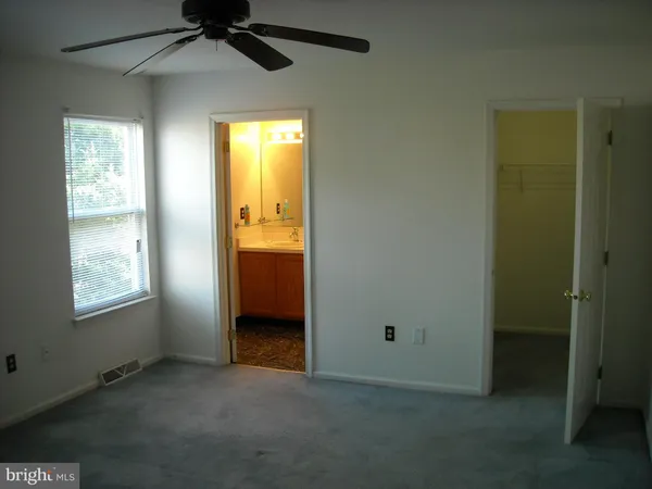 an empty room with windows and a ceiling fan