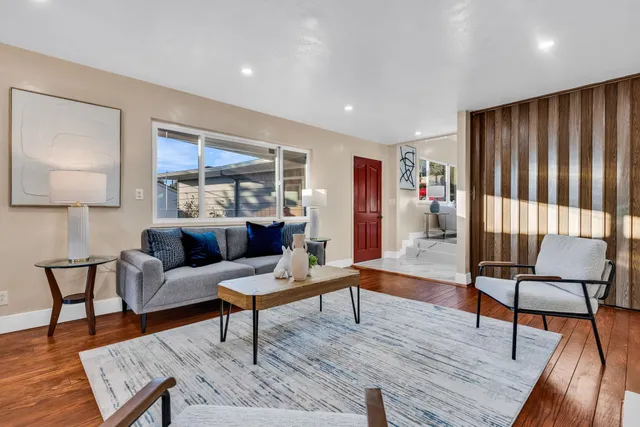 a living room with furniture and a wooden floor