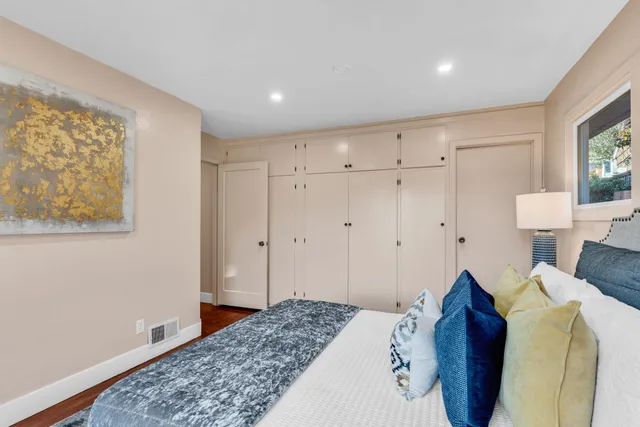 a bedroom with a bed and a painting on the wall