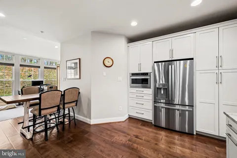 a kitchen with stainless steel appliances a refrigerator and wooden floor