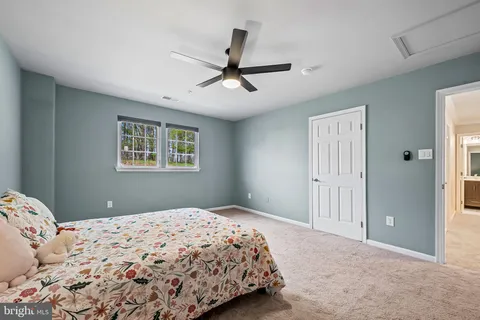 a bedroom with a large bed and a chandelier fan