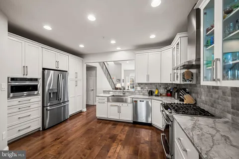a kitchen with stainless steel appliances granite countertop a refrigerator stove and sink