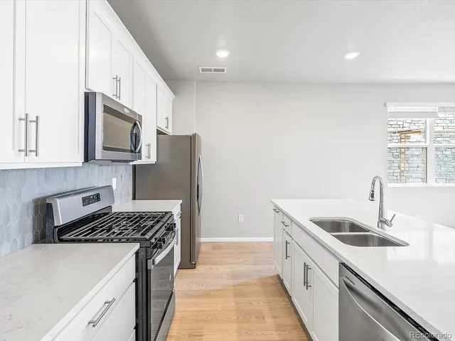 a kitchen with granite countertop a stove and a sink