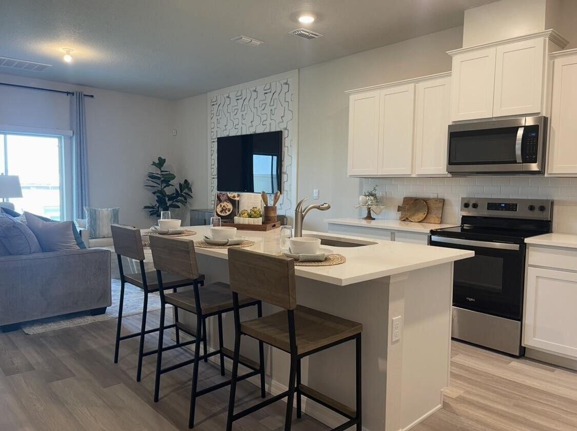 12901 Southwest Forli Way Port St. Lucie, FL 34987 - Photo 3 of 16 a kitchen with a stove a sink and a refrigerator