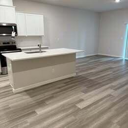 12901 Southwest Forli Way Port St. Lucie, FL 34987 - Photo 4 of 16 a room with a sink cabinets and a wooden floor