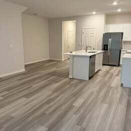12901 Southwest Forli Way Port St. Lucie, FL 34987 - Photo 6 of 16 a large kitchen with a refrigerator a stove top oven a sink dishwasher and a refrigerator with wooden floor