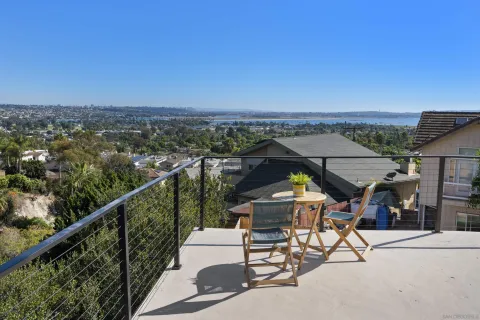a view of a city from a balcony with furniture