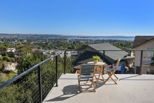 a view of a city from a balcony with furniture