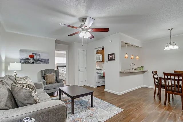 a living room with furniture and a wooden floor
