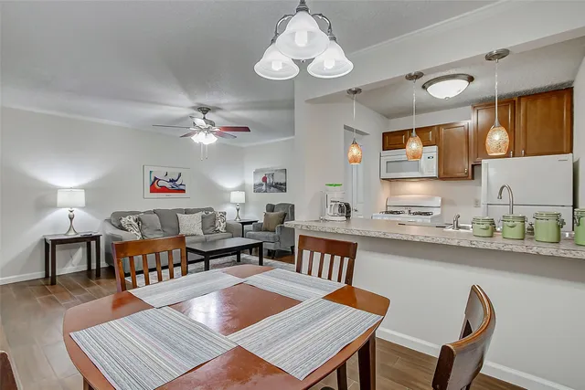 a kitchen with a sink granite counter top a dining table and chairs