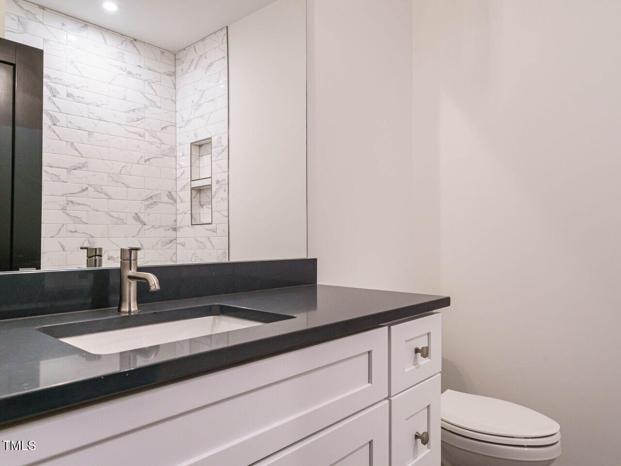 1521 Havenmont Court Raleigh, NC 27608 - Photo 17 of 36 a bathroom with a granite countertop sink a toilet and mirror