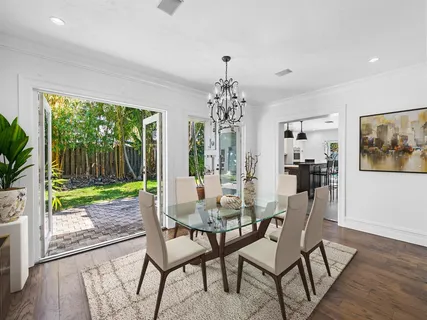 a view of an empty room with wooden floor and garden view