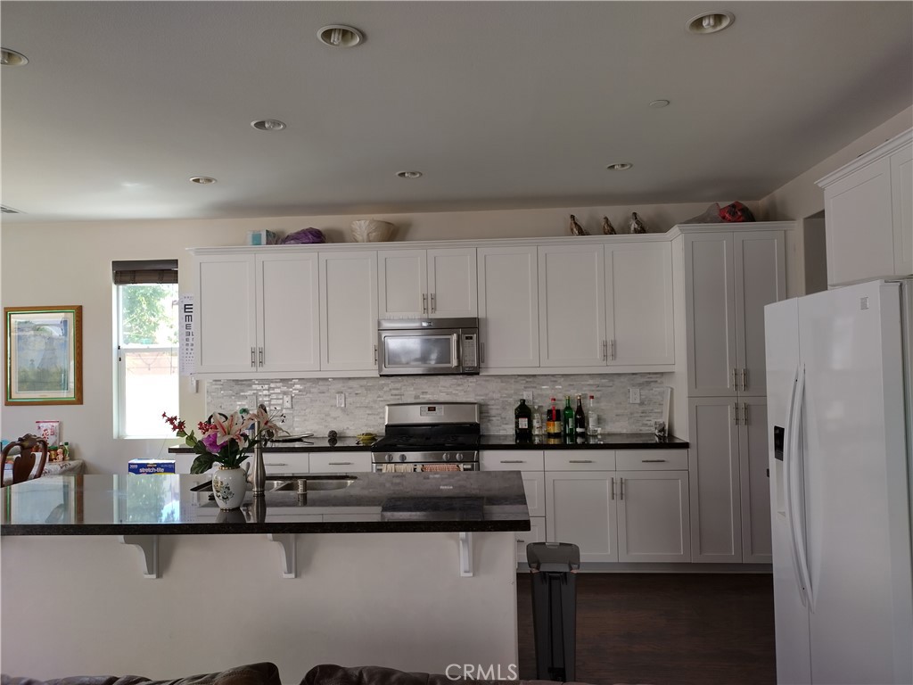 11811 Cramer Road Yucaipa, CA 92399 - Photo 19 of 56 a kitchen with stainless steel appliances granite countertop a refrigerator sink and cabinets