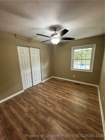 a view of empty room with window and ceiling fan