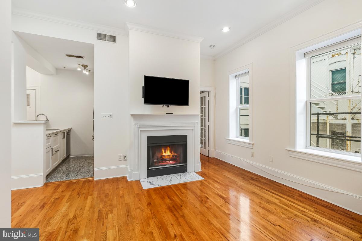 1807 California Street Northwest, Unit 305 Washington, DC 20009 - Photo 13 of 30 a living room with furniture a flat screen tv and a fireplace
