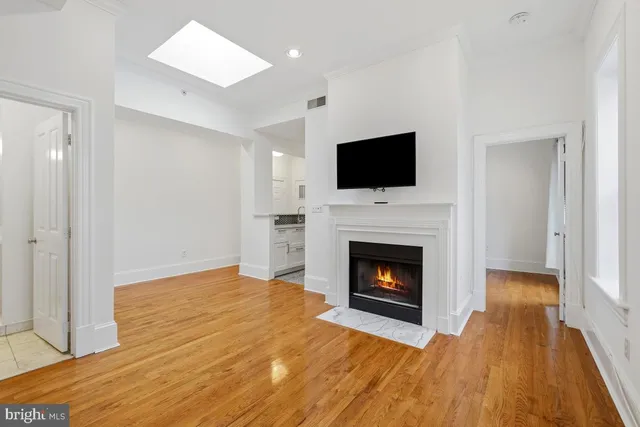 a view of empty room with window and wooden floor