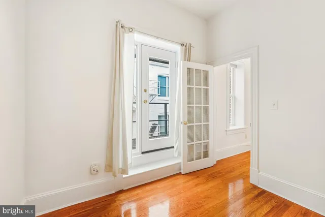 a view of a room with wooden floor and a window