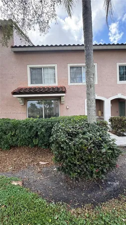 a front view of house with yard and trees in the background