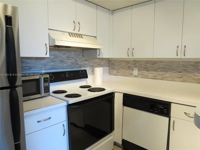 a kitchen with a stove and a white cabinets