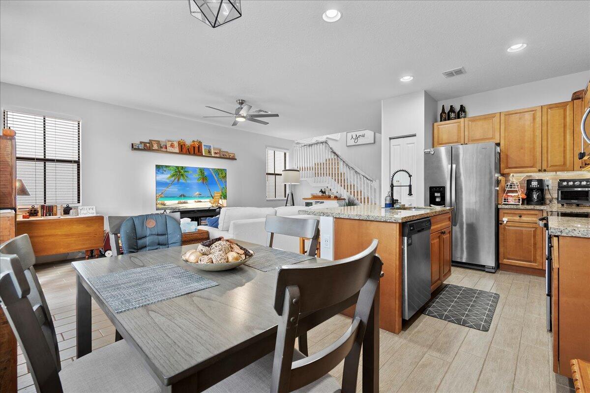 6013 Pine Tree Way Riviera Beach, FL 33410 - Photo 11 of 33 a kitchen with stainless steel appliances granite countertop a dining table and chairs