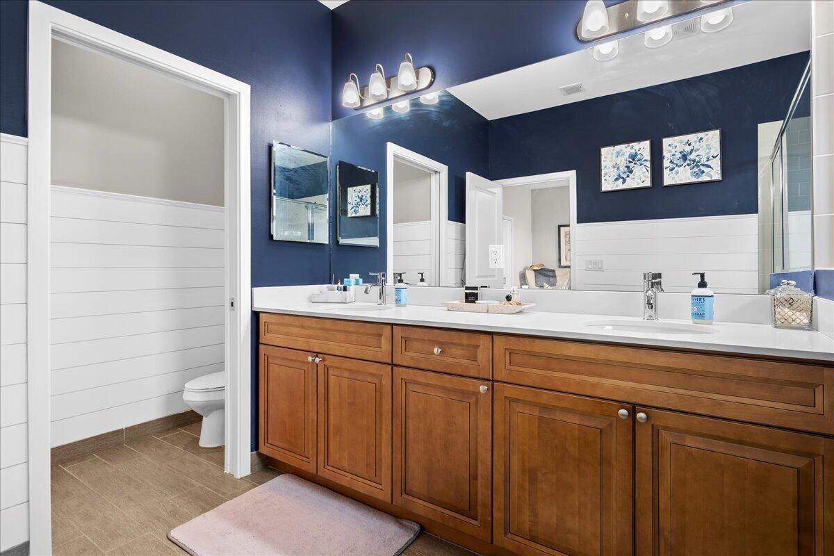 6013 Pine Tree Way Riviera Beach, FL 33410 - Photo 16 of 33 a bathroom with a double vanity sink and a mirror