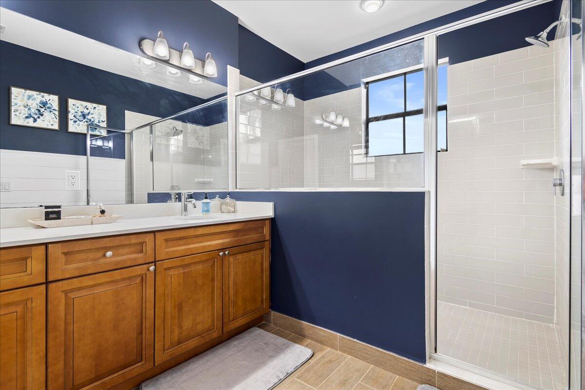 6013 Pine Tree Way Riviera Beach, FL 33410 - Photo 17 of 33 a bathroom with a double vanity sink and mirror