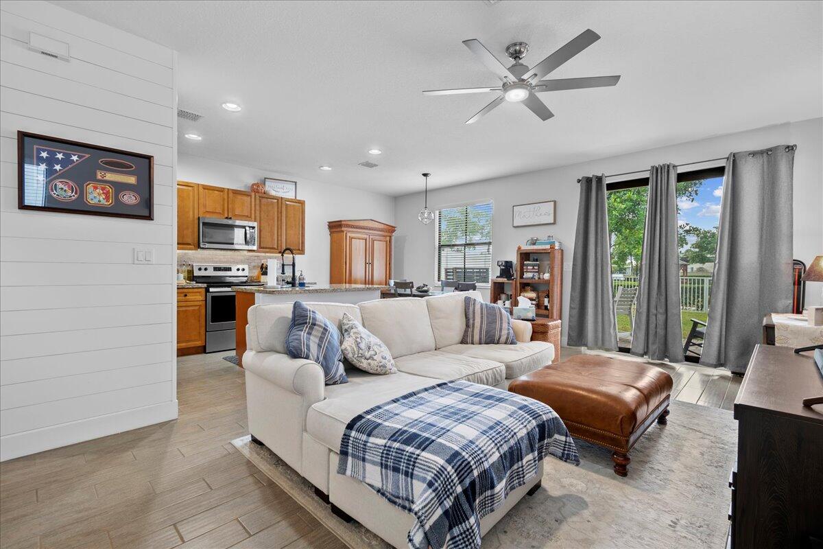 6013 Pine Tree Way Riviera Beach, FL 33410 - Photo 6 of 33 a living room with furniture ceiling fan and a large window