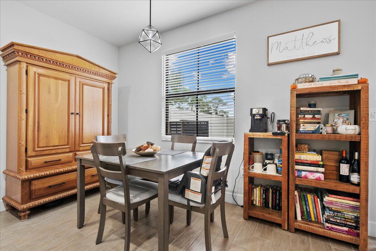 6013 Pine Tree Way Riviera Beach, FL 33410 - Photo 8 of 33 a view of a dining room with furniture and a book shelf
