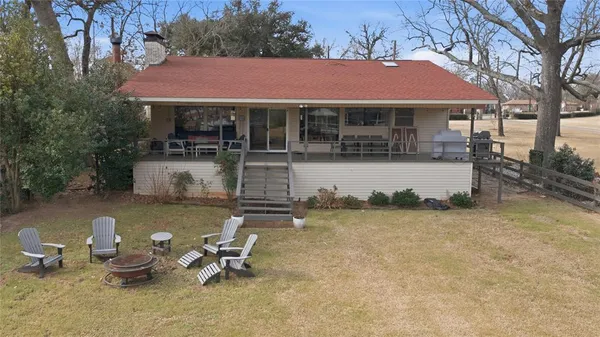 a backyard of a house with table and chairs under an umbrella