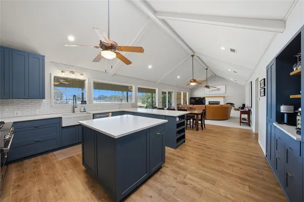 a kitchen with a stove a counter top space a sink cabinets and wooden floor