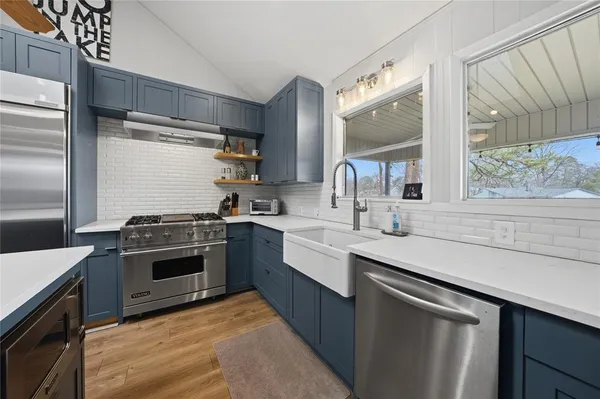 a kitchen with a sink stove and cabinets