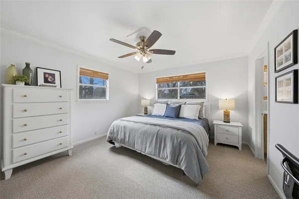 a bed room with a bed and a ceiling fan