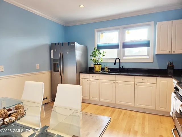 a kitchen with stainless steel appliances a refrigerator sink and white cabinets