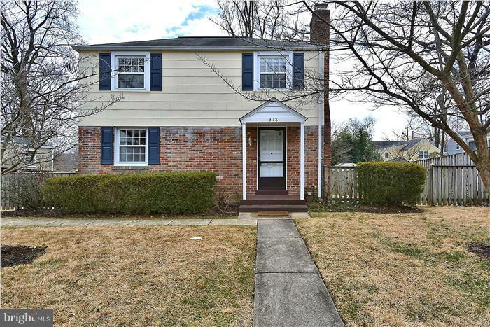 a front view of a house with a yard and trees
