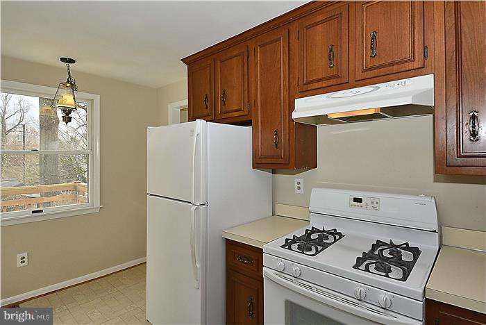 318 Whitestone Road Silver Spring, MD 20901 - Photo 10 of 28 a kitchen with a refrigerator a stove a sink and cabinets