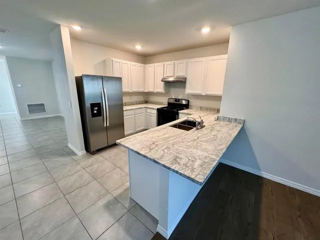a kitchen with stainless steel appliances a refrigerator sink and microwave