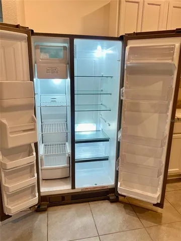 a view of a kitchen with kitchen island a sink wooden floor and stainless steel appliances